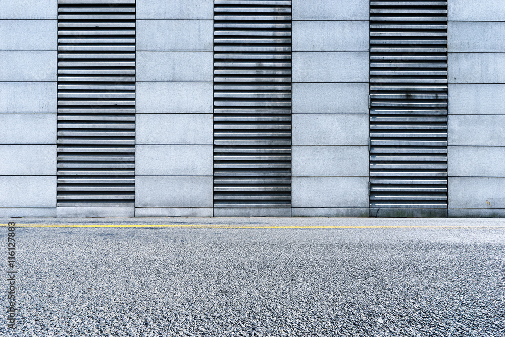 empty asphalt road near abstract wall