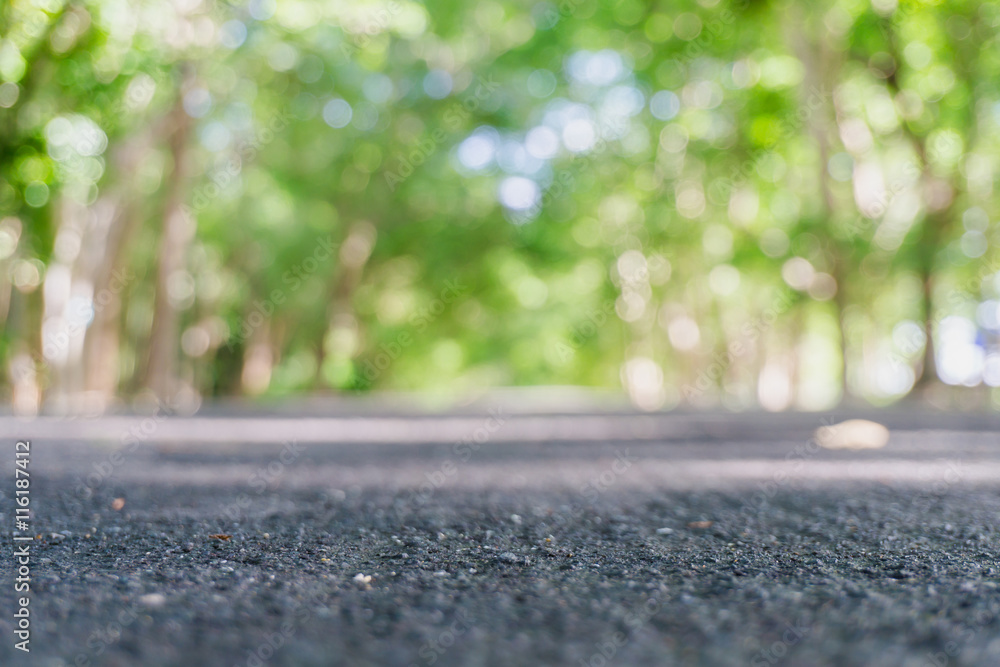 Lane Blacktop through autumn forest park and trees bokeh.