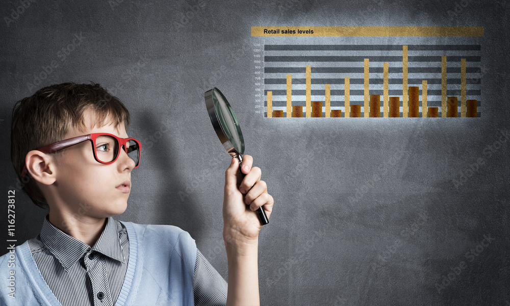 Curious school boy with magnifier