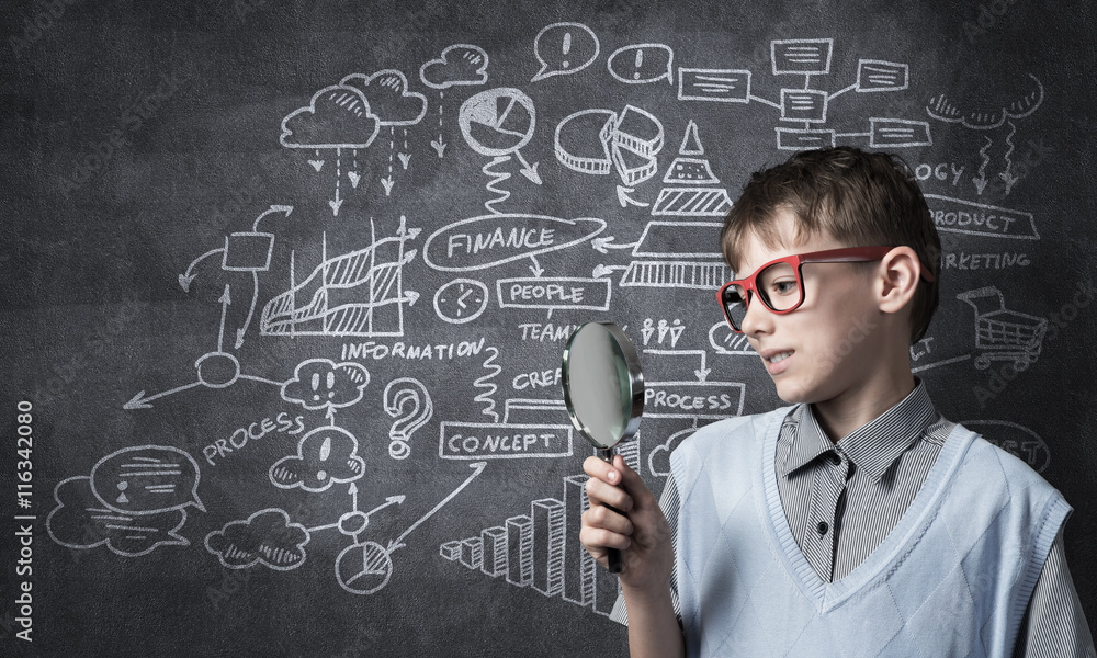 Curious school boy with magnifier