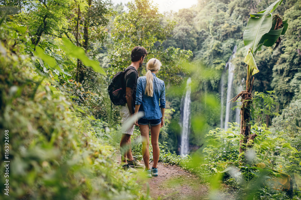 Couple of hikers viewing waterfall