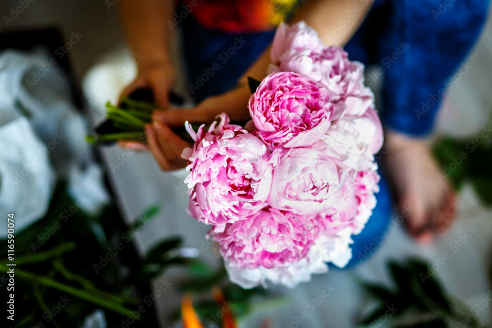 Florist making a bouguet of peonies