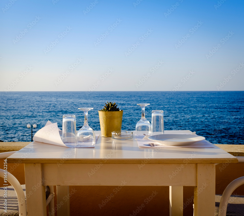 Tisch im Restaurant mit Meerblick bei Sonnenuntergang