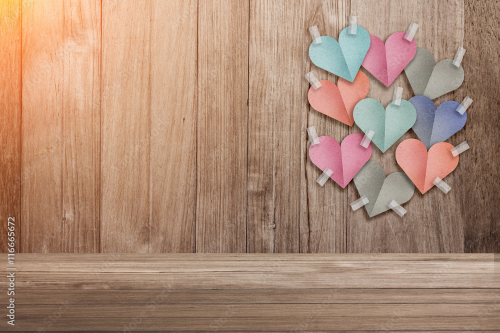 colorful heart shape paper cut stick on old wooden background