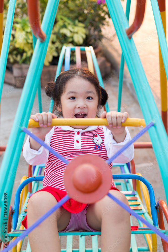 Asian girl is playing on the playground.