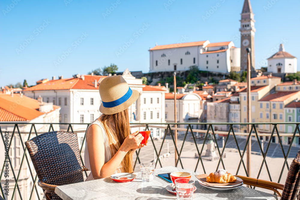 年轻的女性旅行者坐在皮兰老城的中心广场上用手机旅行