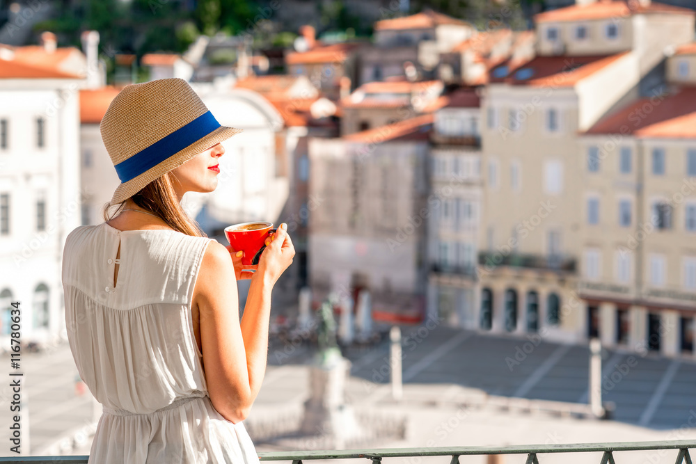 年轻的女性旅行者坐在皮兰老城的中心广场上使用手机。旅行