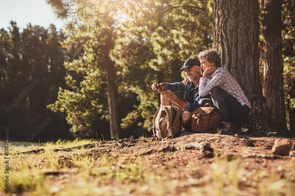 Smiling mature couple looking for directions with compass