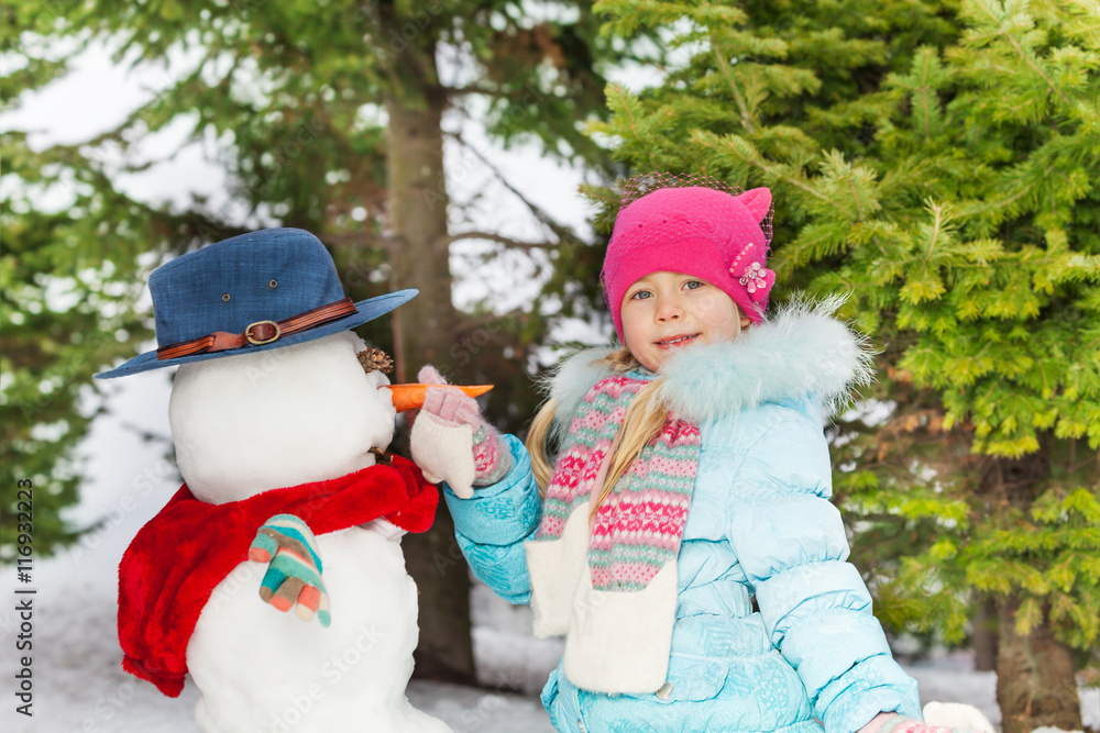 小女孩放胡萝卜堆雪人