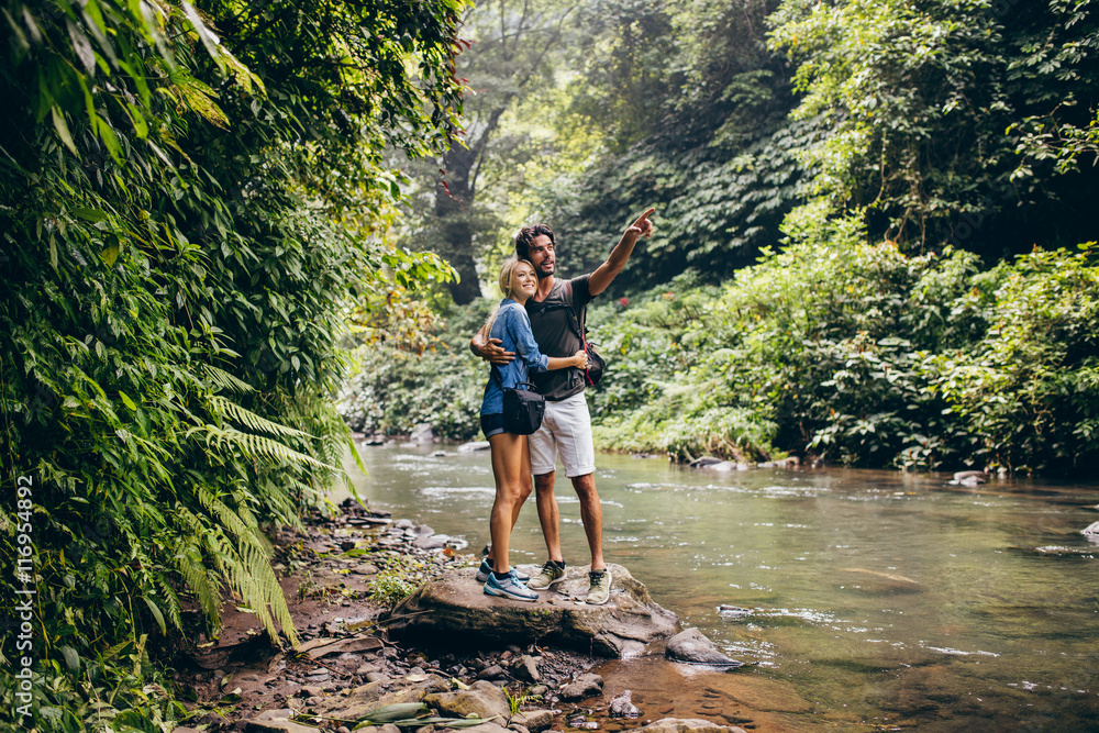 Hiking couple by stream looking at a view