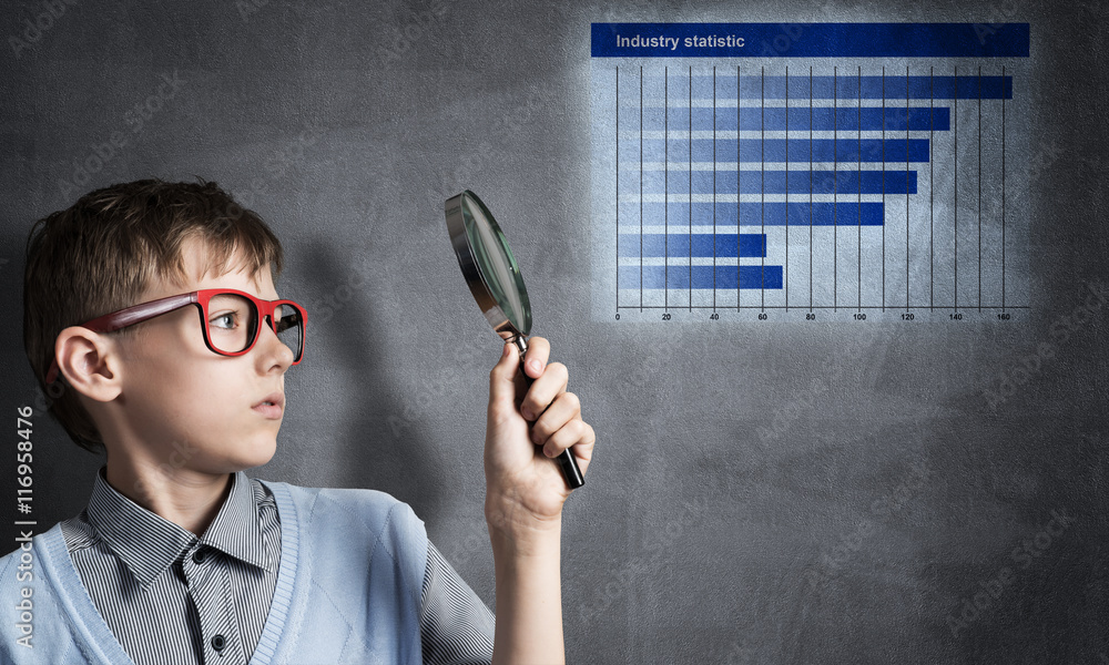 Curious school boy with magnifier