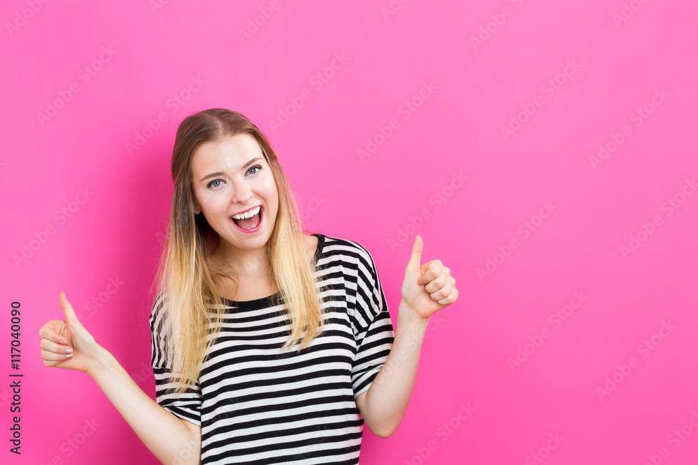 Happy young woman giving thumbs up