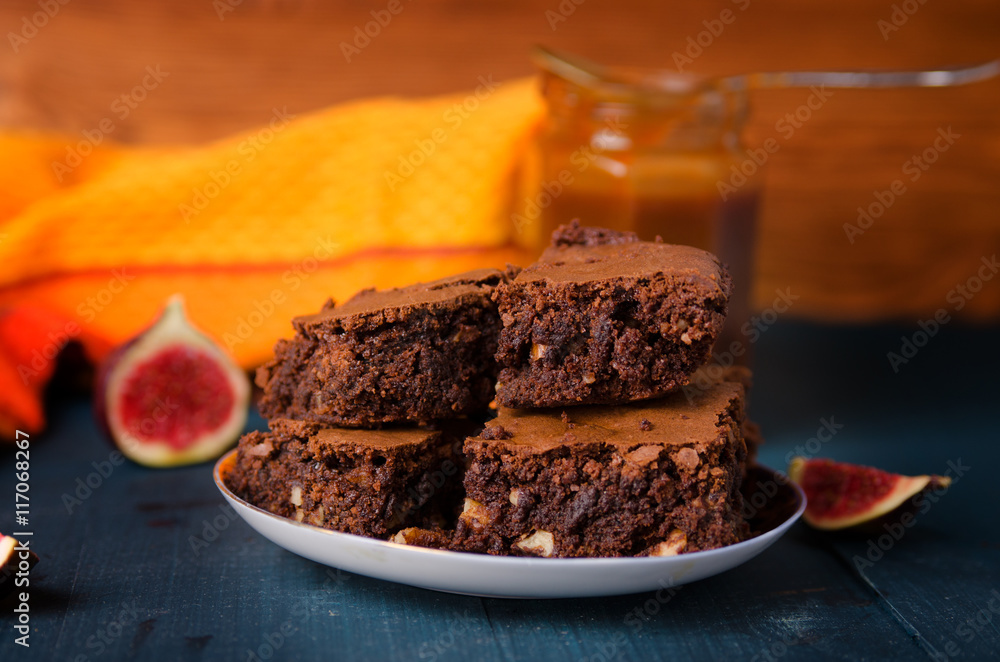 Brownie with walnuts, figs on a dark blue background with a yellow cloth