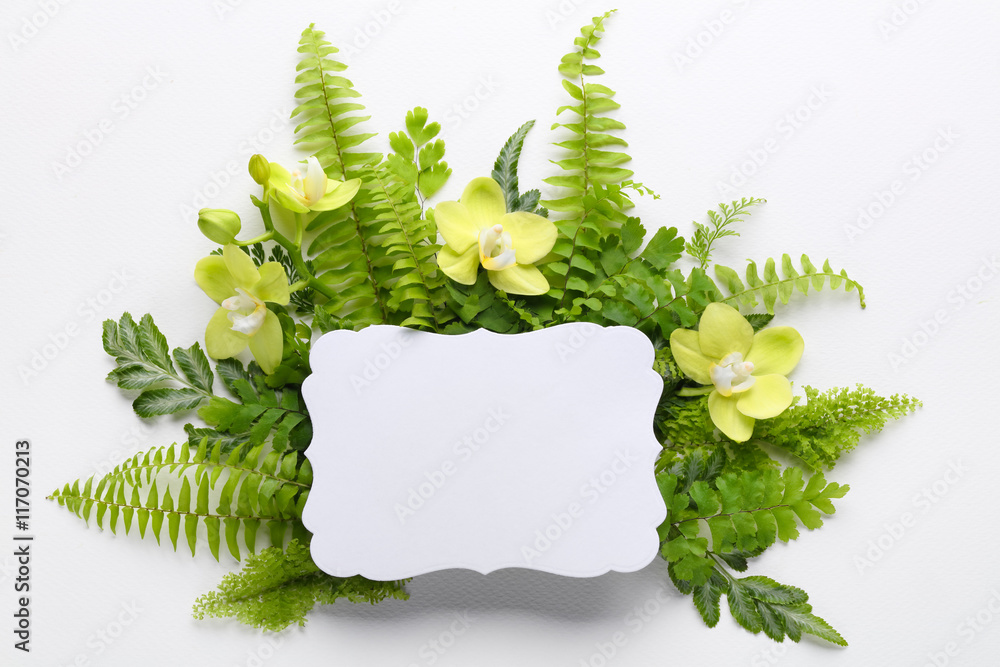 Orchid and fern leaf with blank paper card