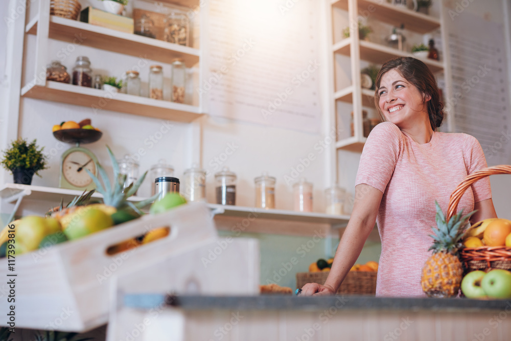 Beautiful woman standing behind the counter of her juice bar