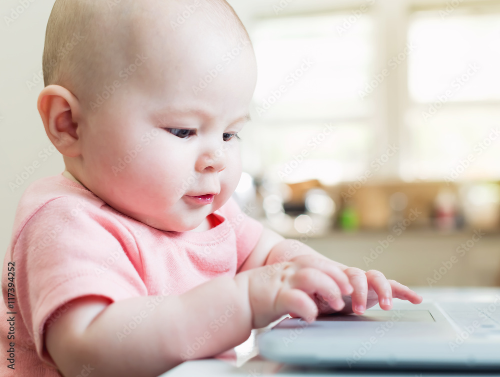 Happy baby girl using laptop computer