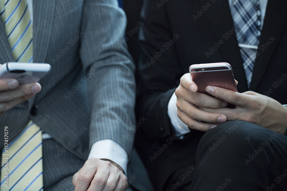 The hands of the young businessmen of two people who have a smartphone