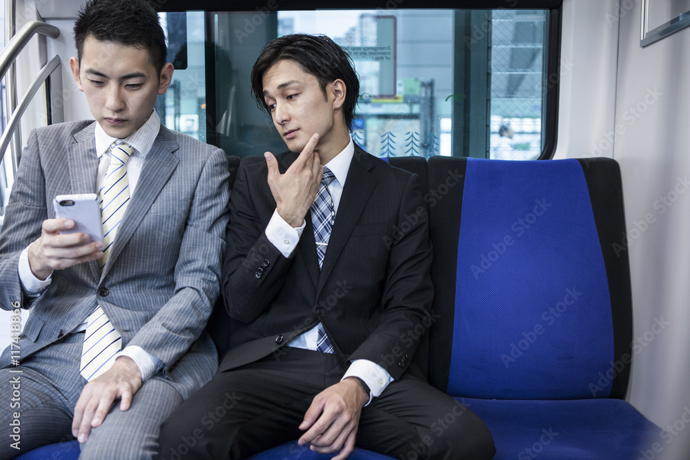 Businessmen are crazy about the smartphone on a train