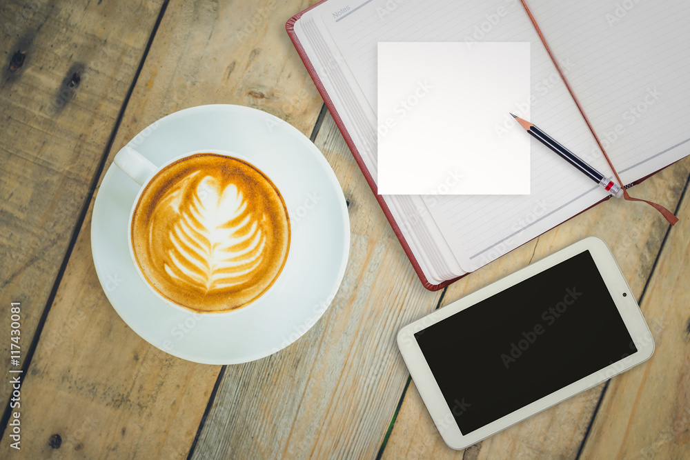 Top view of coffee cup with notebook and smart phone on wooden t