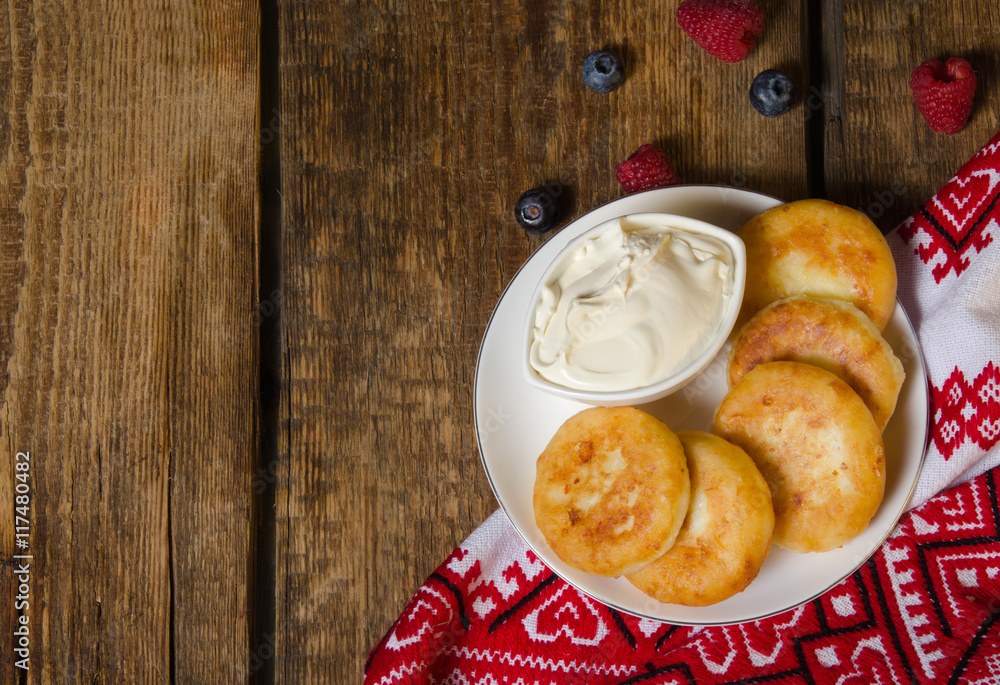 Russian cottage cheese pancakes with raspberries on wooden background. Top view.