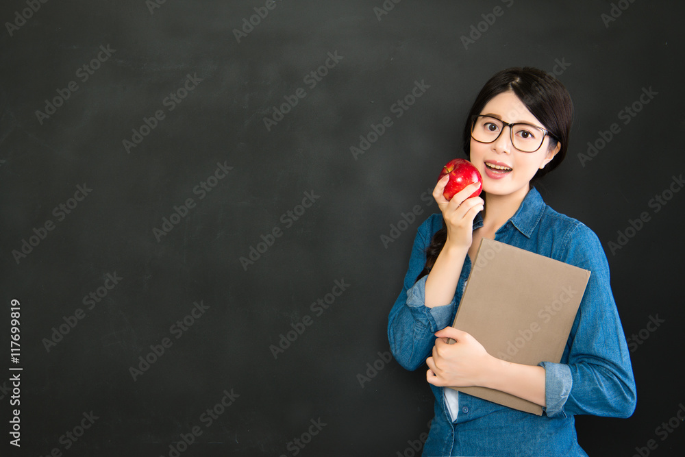 happy girl student with glasses and book in front blackboard