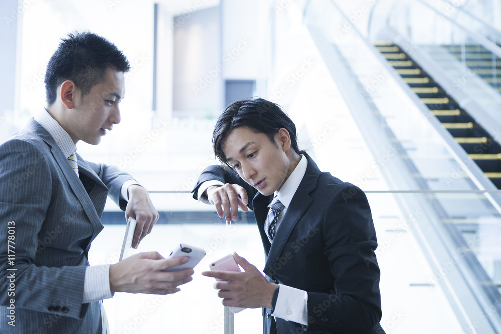 Young businessman has been the stand talking while looking at the smartphone