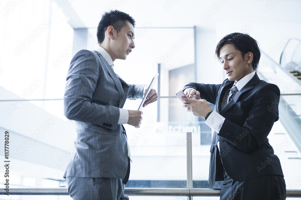 Young businessman has been the stand talking in while watching the tablet