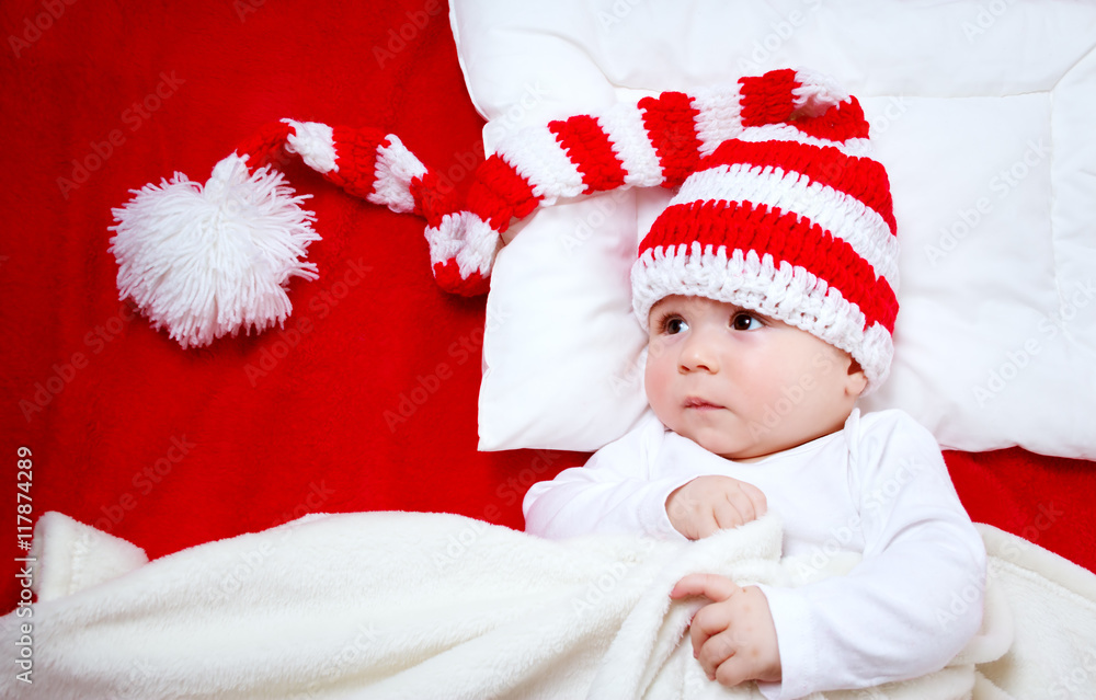 Sleepy baby on red blanket