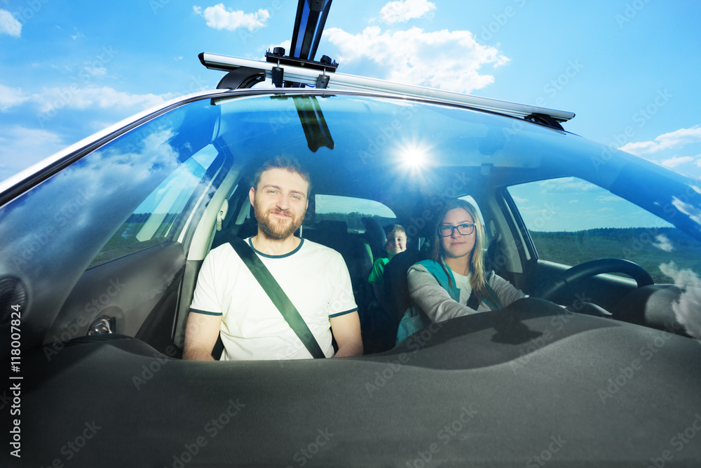 Happy young family during car trip on sunny day