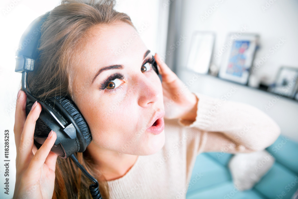 Woman with headphones singing and listening to music at home