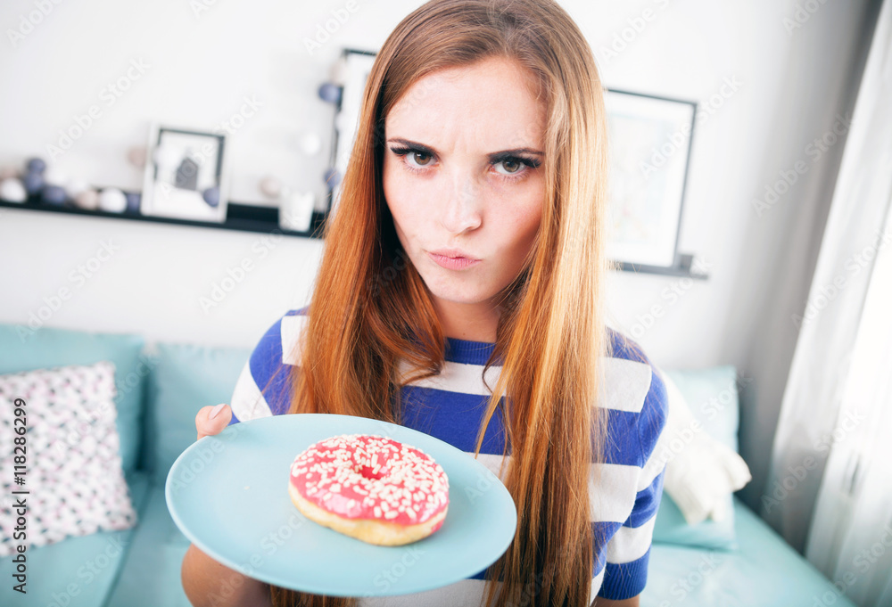 Woman on diet with donut thinking about eating it