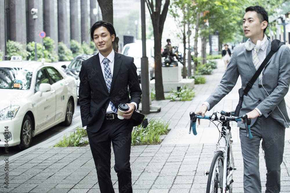 Businessman is walking while talking down the bicycle