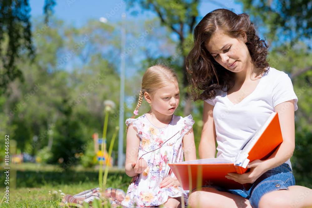 girl and a young woman reading a book together