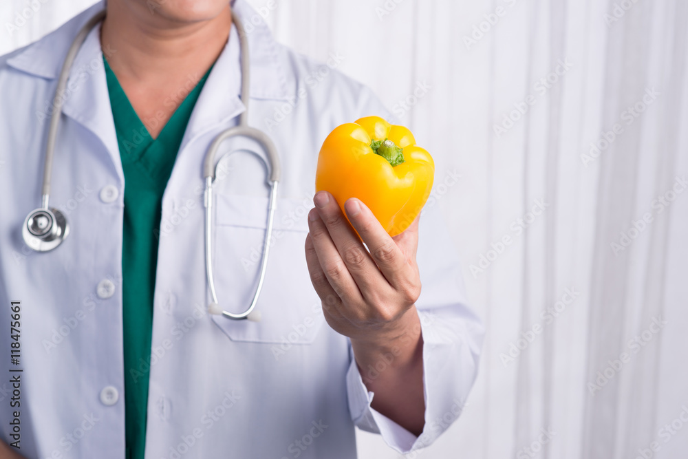 Nurse or male doctor giving bell pepper smiling. Health care con