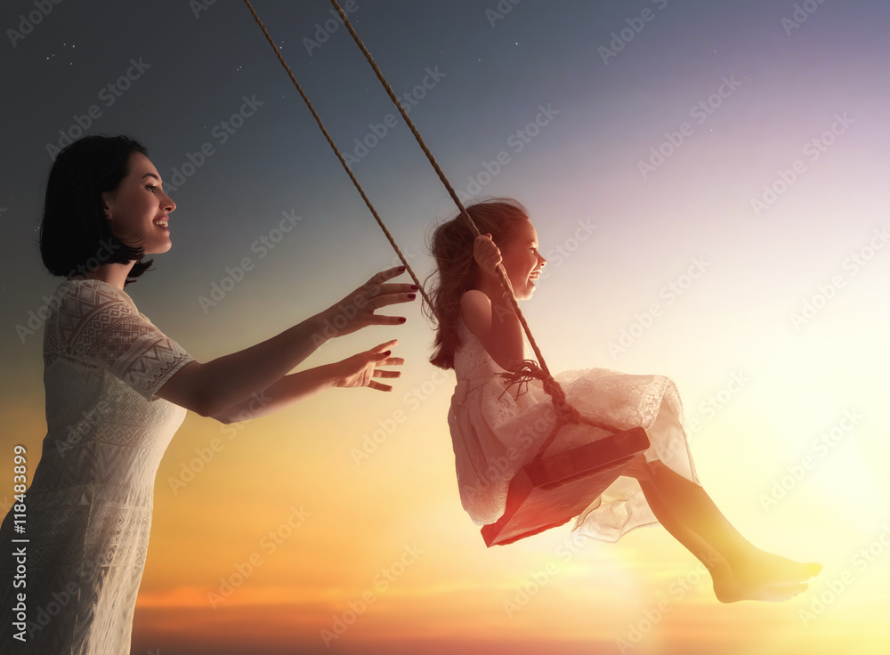 mother and  daughter swinging on swings