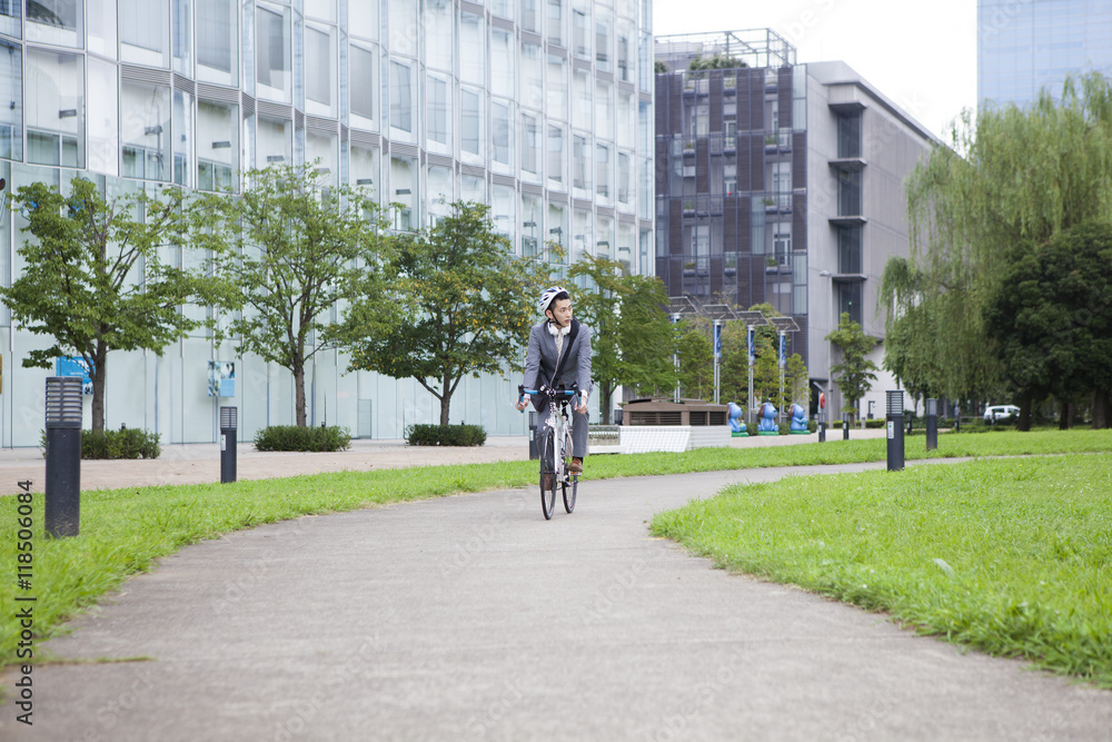 Businessman is riding a bicycle wearing a helmet