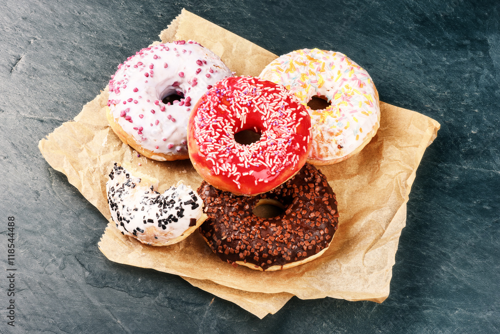 Donuts glazed with various sprinkles on dark blue background