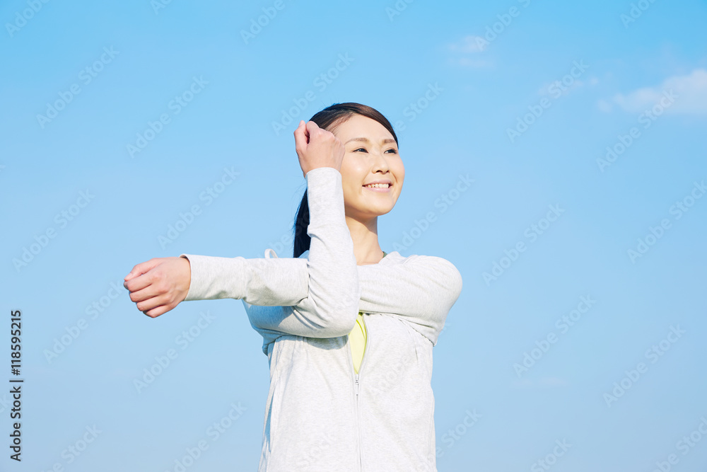 ストレッチする女性　青空背景