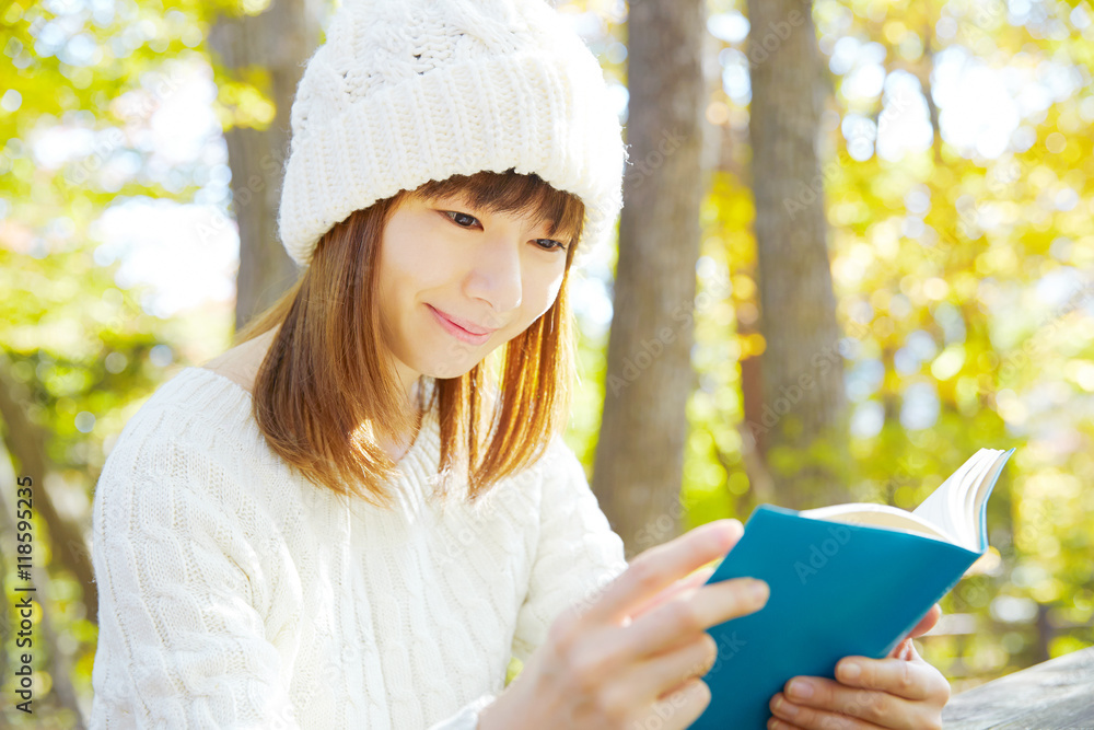 秋の紅葉の中の女性　読書