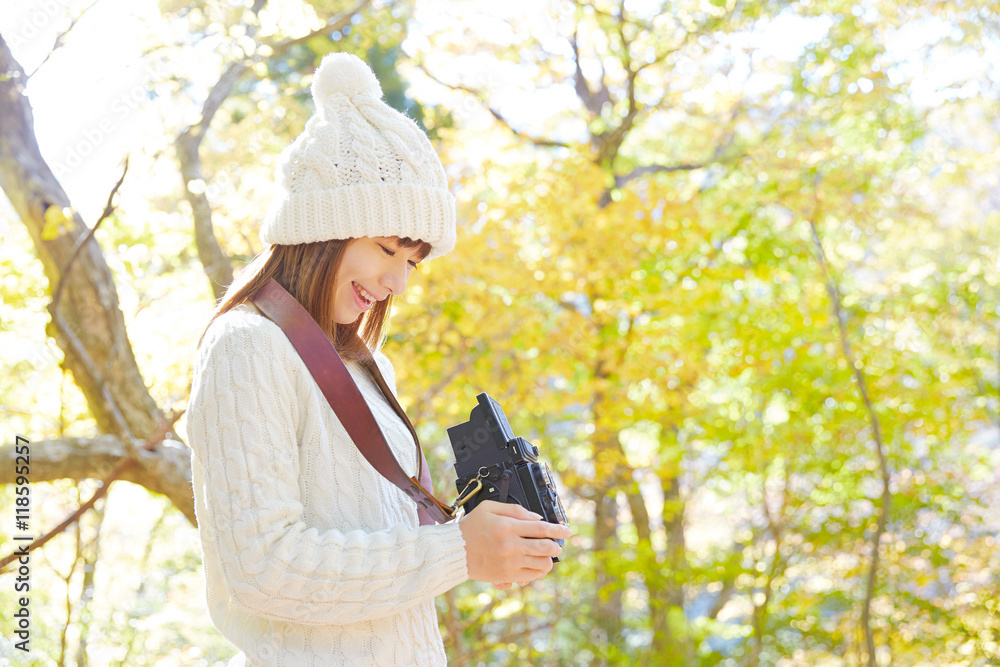 秋の紅葉の中の女性　写真を撮る