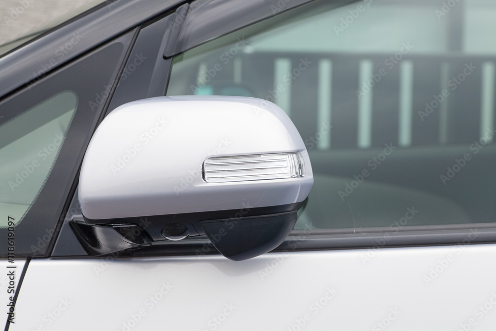 Side rear-view mirror closed for safety at car park.