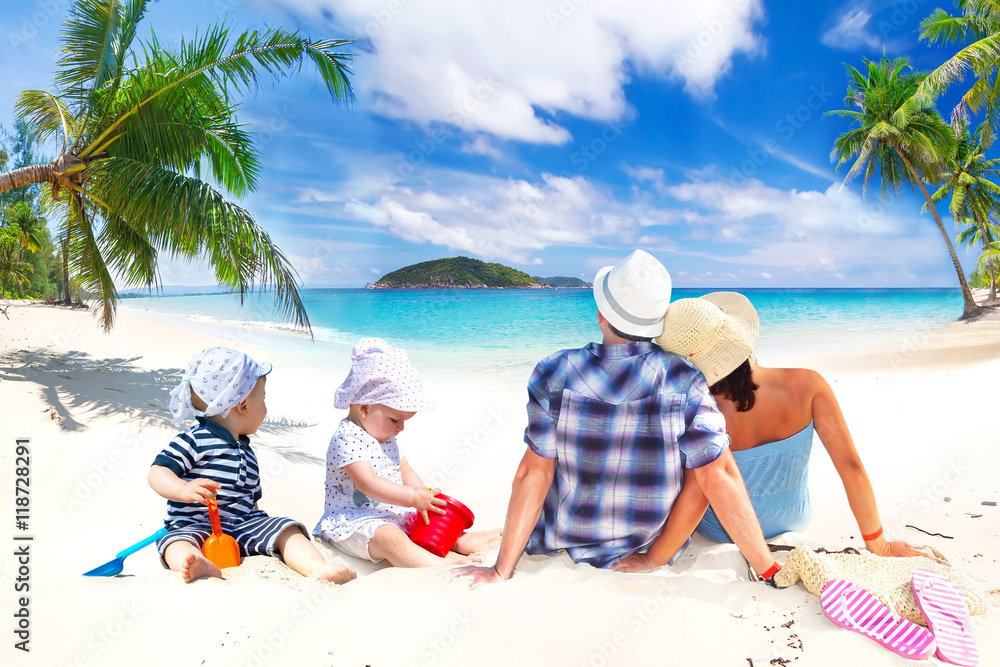 Family with twins on sun holidays at the tropical beach