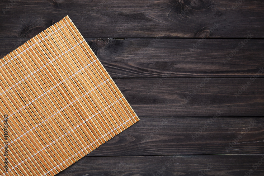 Bamboo mat on wooden table, top view