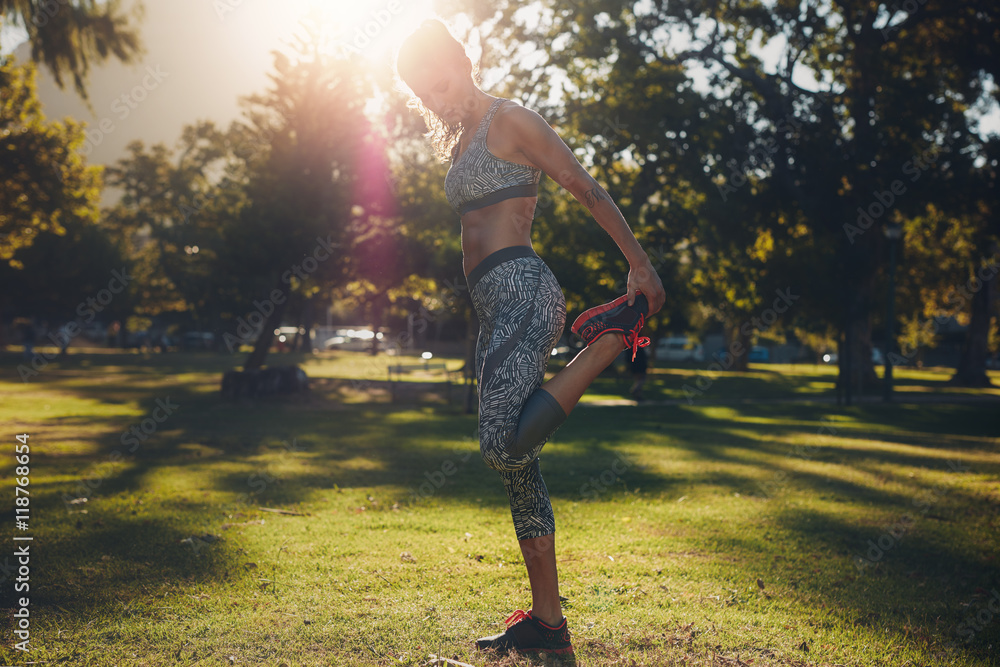 Healthy young woman stretching in a park