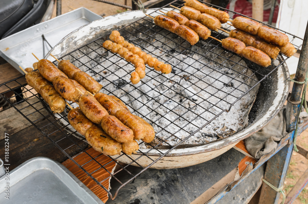 Display for sell BBQ with fiery sausages on the grill