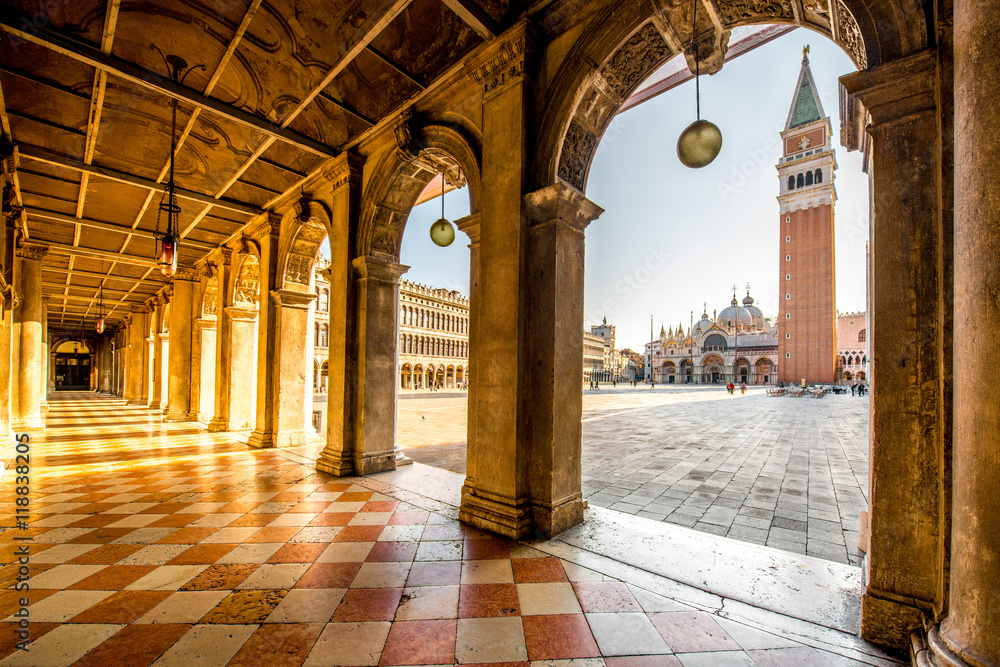 Arches of Correr museum with San Marco tower on the main square in the morning in Venice