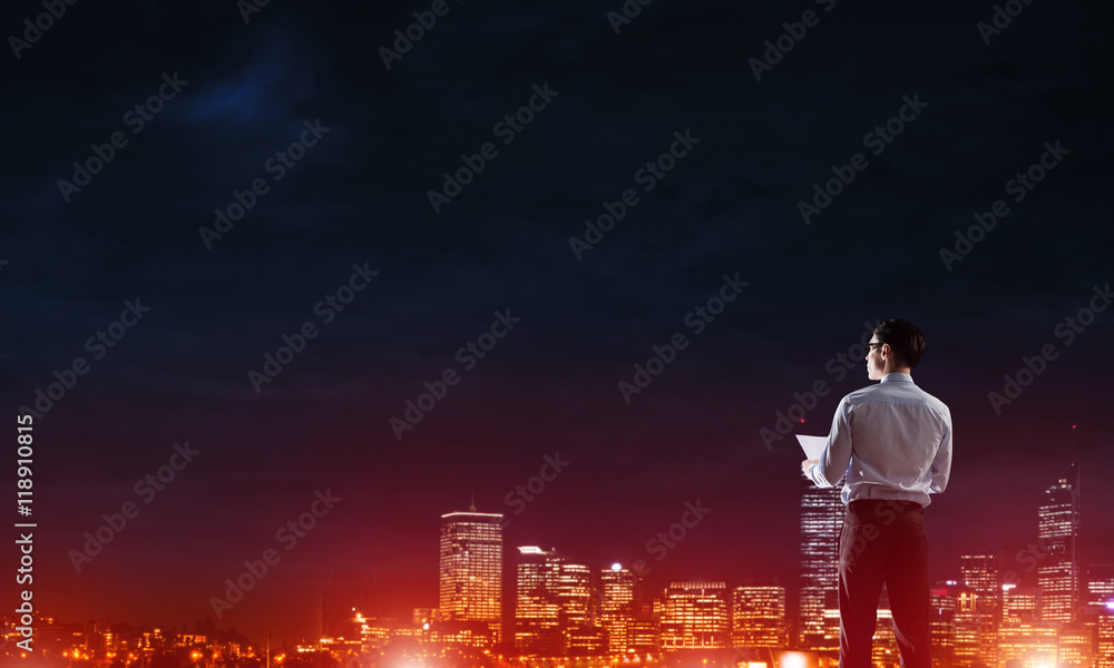 Businessman viewing night glowing city