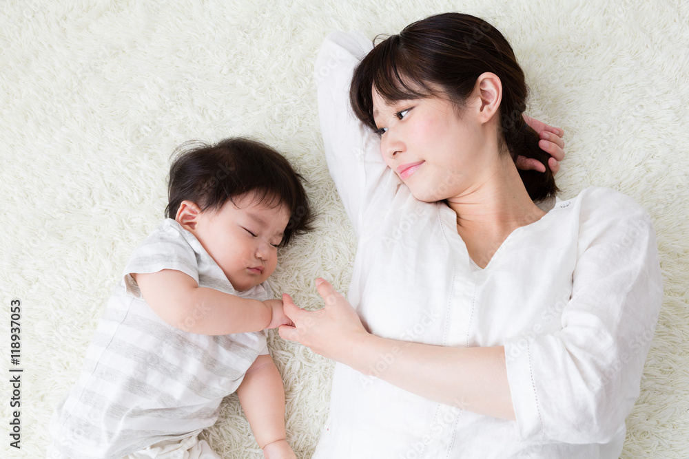 mother and baby lying on the carpet