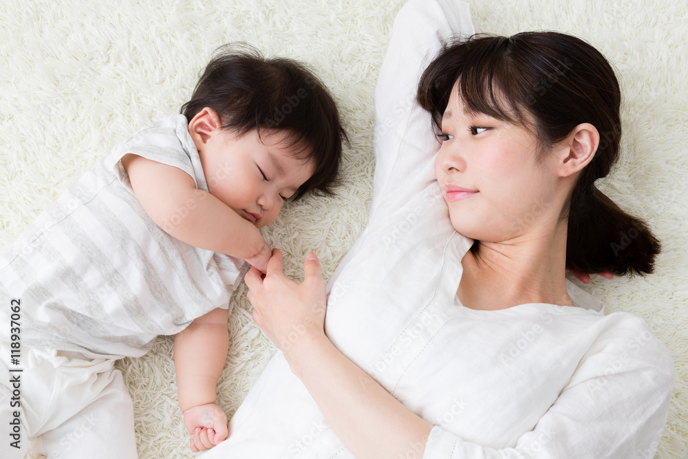 mother and baby lying on the carpet