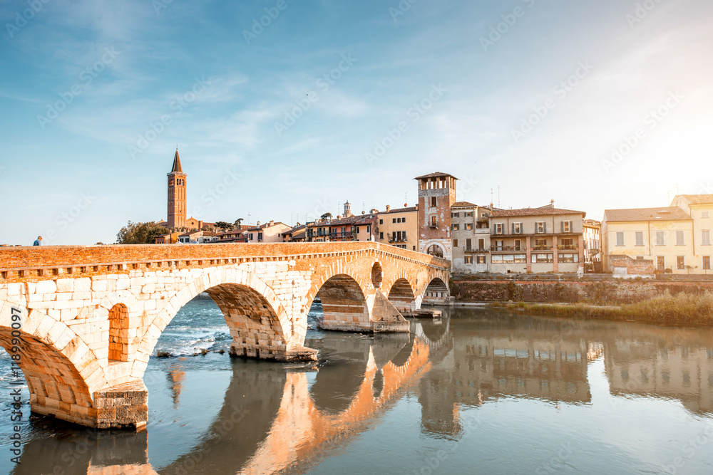 Verona cityscape view on the riverside with historical buildings and towers on the sunset